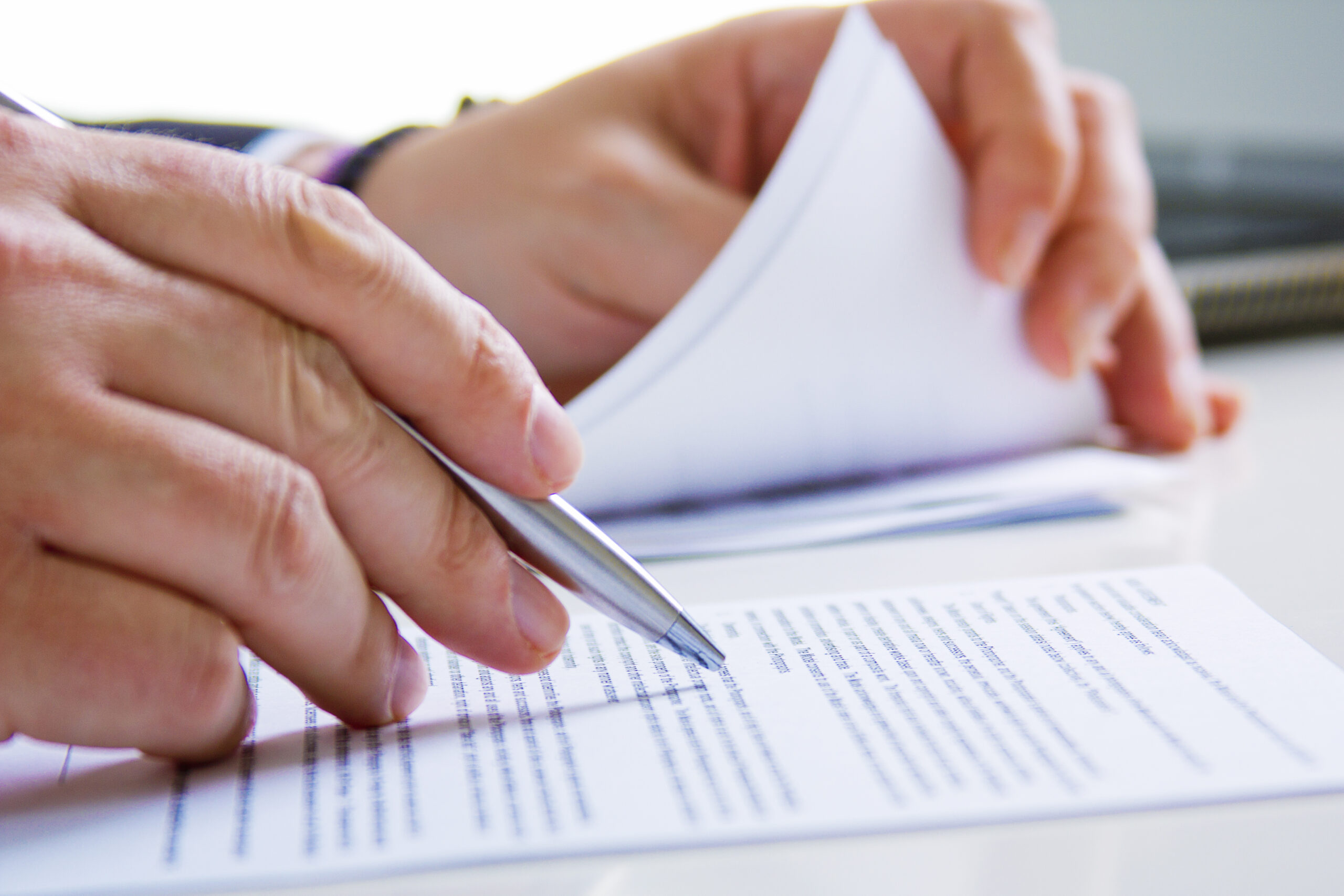Hands of Business man in dark suit writing in his datebook